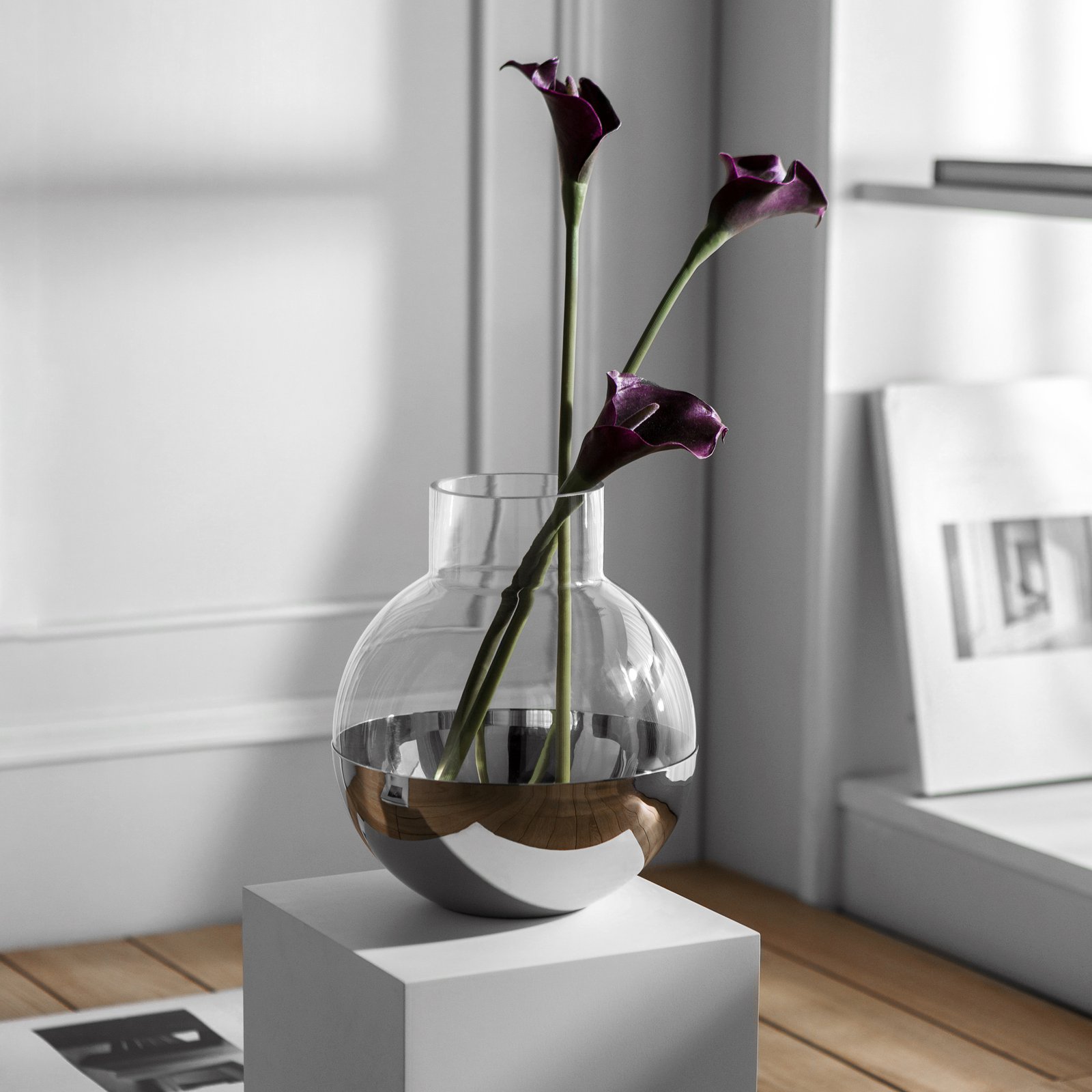 Steel Sphere Vase showcased as a Luxury Mirror Polished Floral Vessel, reflecting a contemporary living room environment on its curved surface.