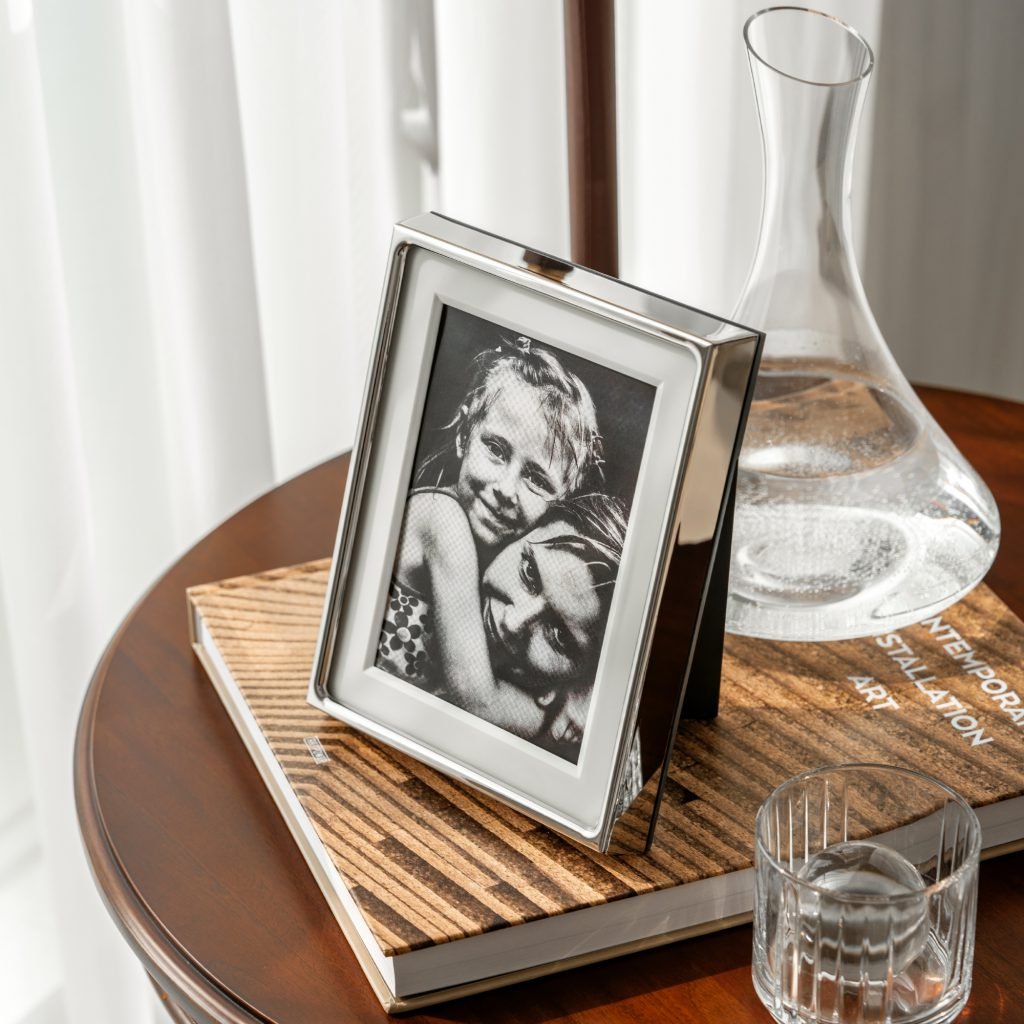 Steel Picture Frame (SS-18) featuring mirror-polished cylindrical steel supports and a crystal-clear frameless glass interface, showcased as a Luxury Mirror Polished Photo Display.