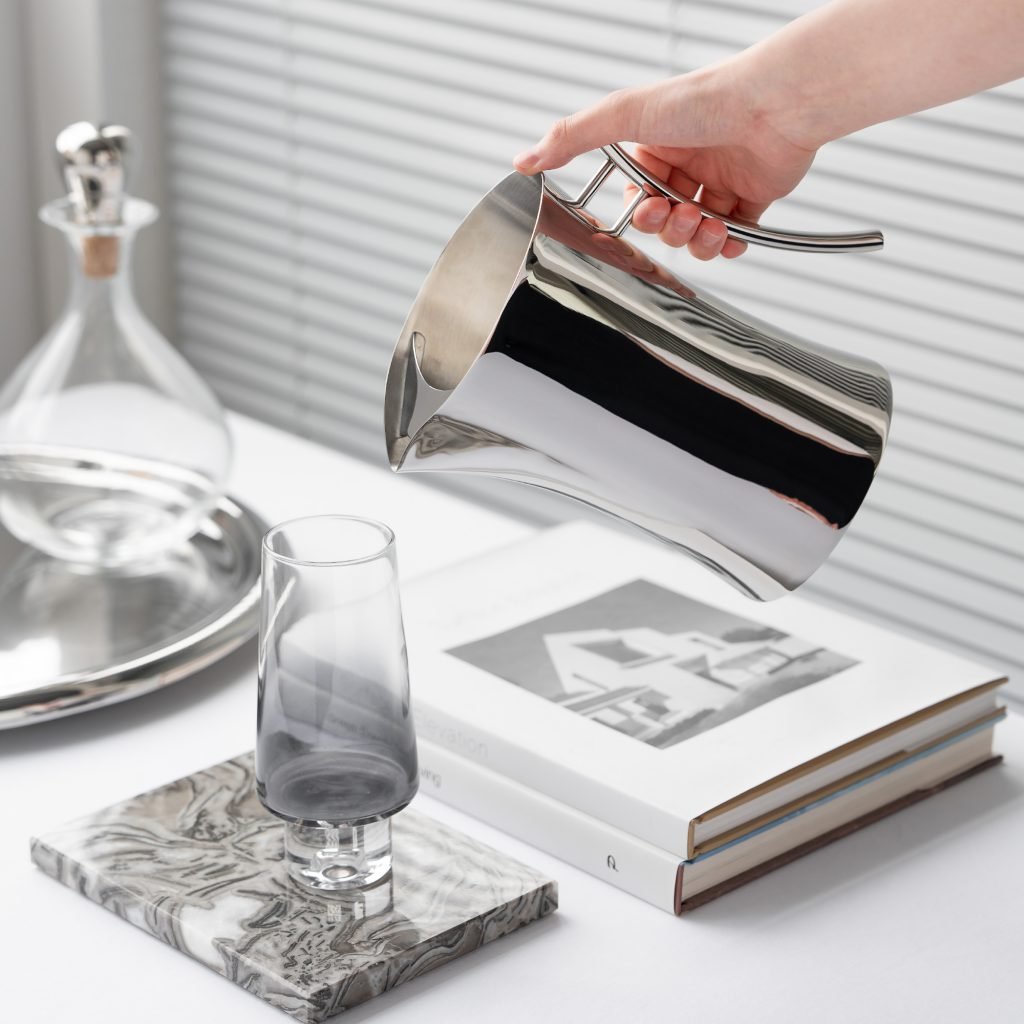 Steel Water Pitcher (SS-27) featuring a mirror-polished conical body and an integrated ergonomic handle for professional beverage service, showcased as a Luxury Mirror Polished Beverage Server.