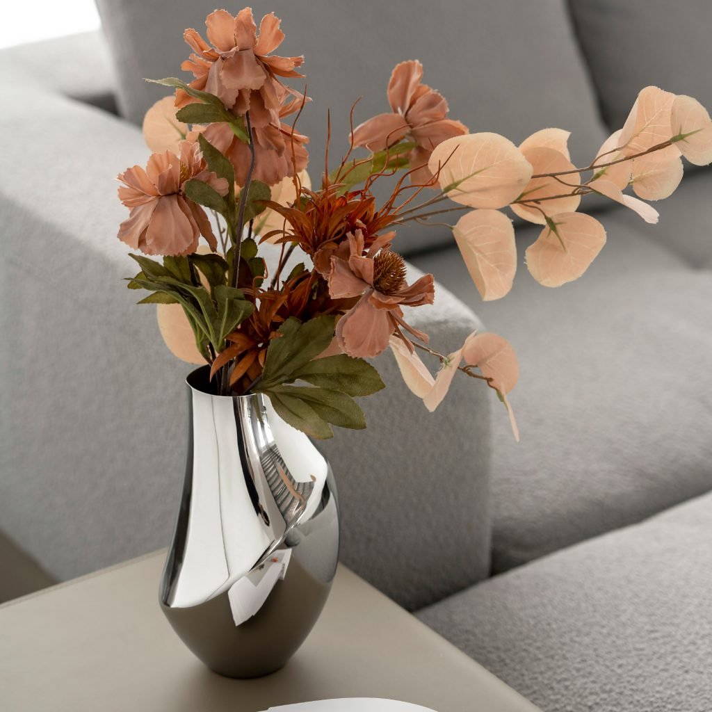 Steel Minimalist Vase (SS-38) featuring a mirror-polished cylindrical body holding a single calla lily, showcased as a Luxury Mirror Polished Flower Vessel.