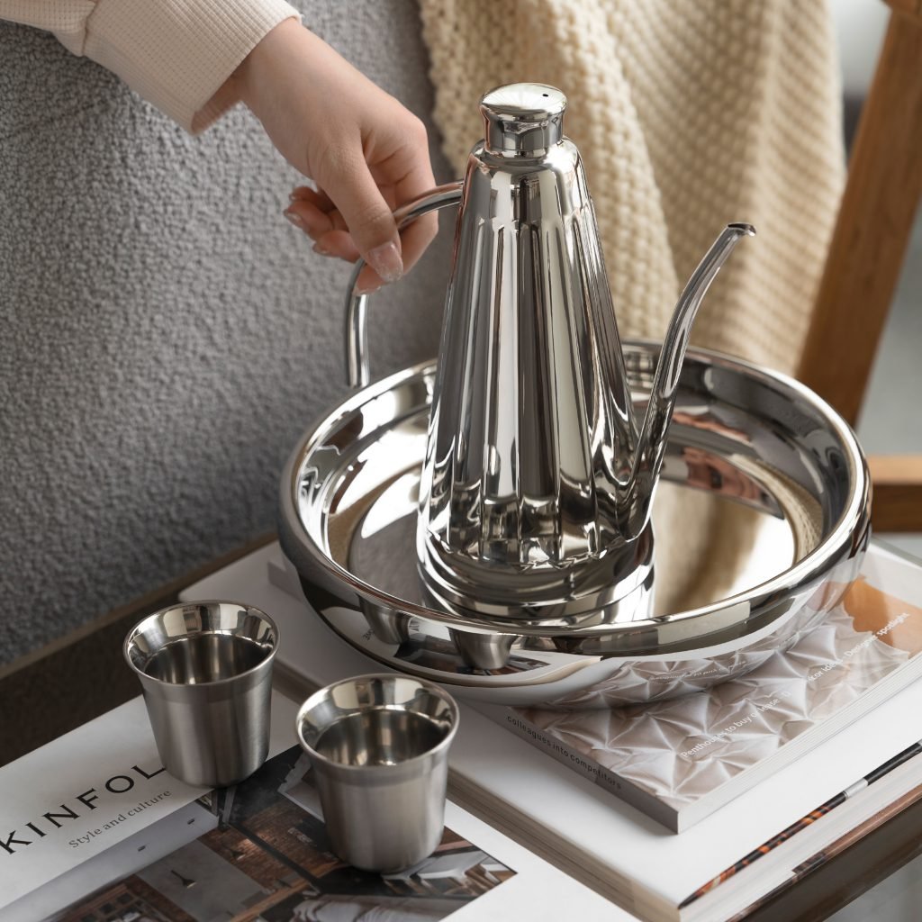 Steel Coffee Set featuring a cylindrical coffee pot and matching server, showcased as an Executive Metallic Coffee Service on a minimalist surface.