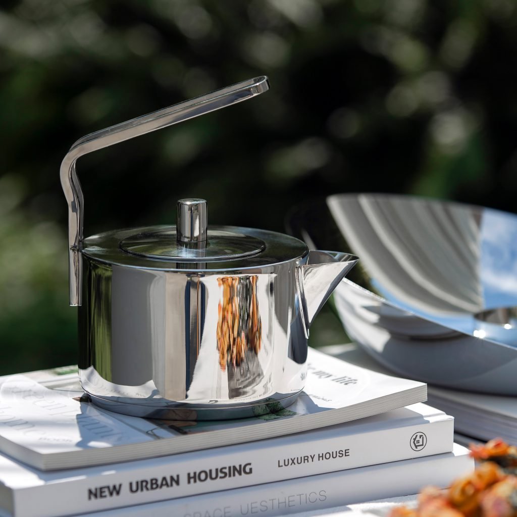 Modern Teapot standing solo on a dark wooden desk, showcased as a Luxury Mirror Polished Tea Server for professional environments.