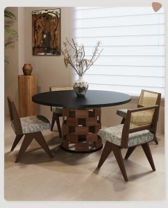 Eye-level shot of Apexerahomelife JX-DTS-005 Solid Wood Round Dining Set featuring a matte black round tabletop, a unique woven-style wooden pedestal base, and three mid-century modern chairs with rattan backrests.