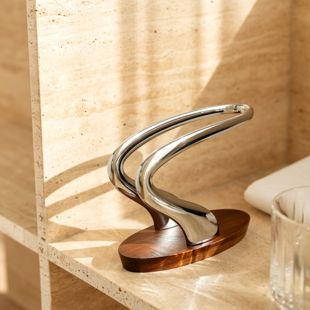 Steel Napkin Holder placed on a dark slate tabletop with crisp white linens, representing Reflective High-End Minimalist Art elegance.