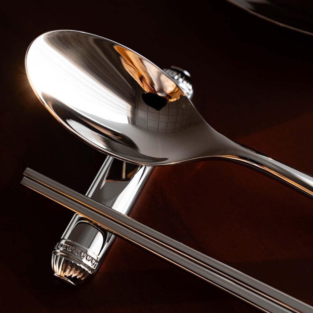 Steel Flatware Rest (SS-101) featuring a mirror-polished cylindrical body supporting a knife and fork, showcased as Luxury Mirror Polished Cutlery Support.
