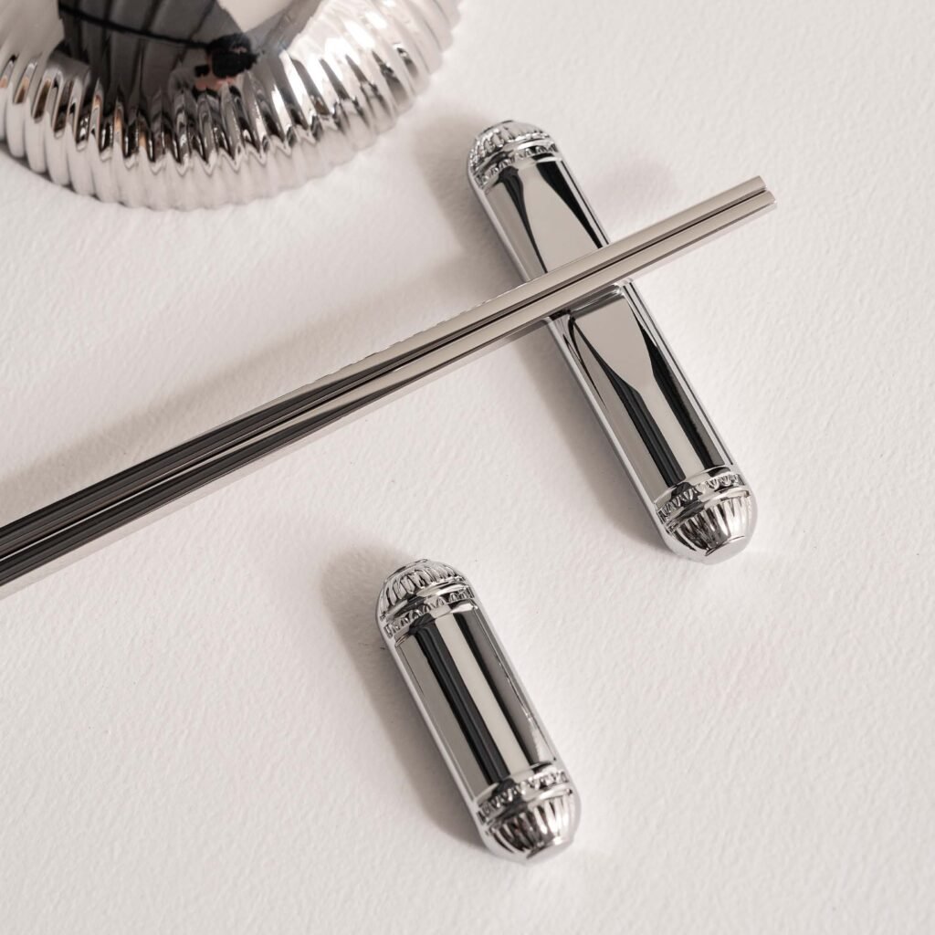 Close-up of the Modernist Metallic Tableware, highlighting the heavy-duty solid steel construction and the flawless, deep-set reflective finish.