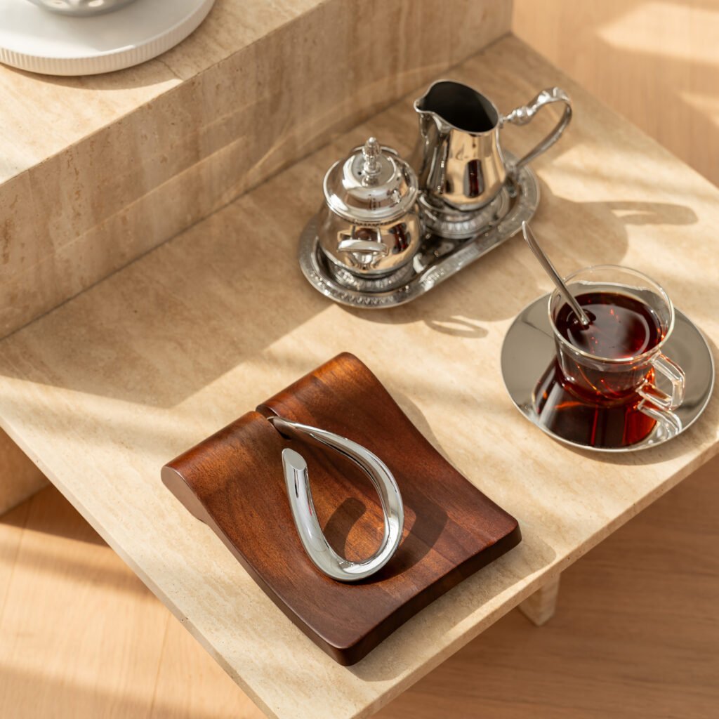 Close-up of the Modernist Horizontal Metalware, highlighting the precision-weighted arm and the flawless, panoramic reflection across the steel tray surface.