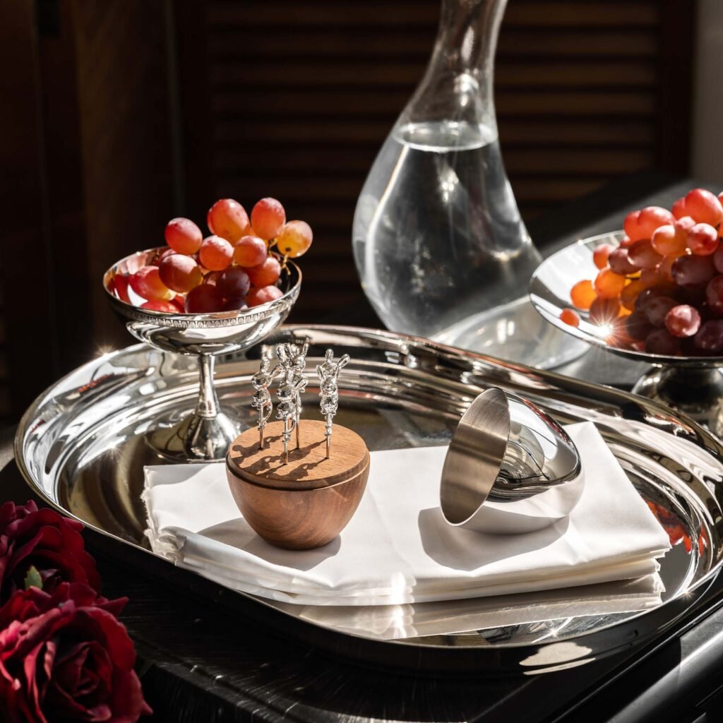 Close-up of the Modernist Bird Design Tableware, highlighting the precision-milled bird finials and the flawless, deep-set reflective finish.