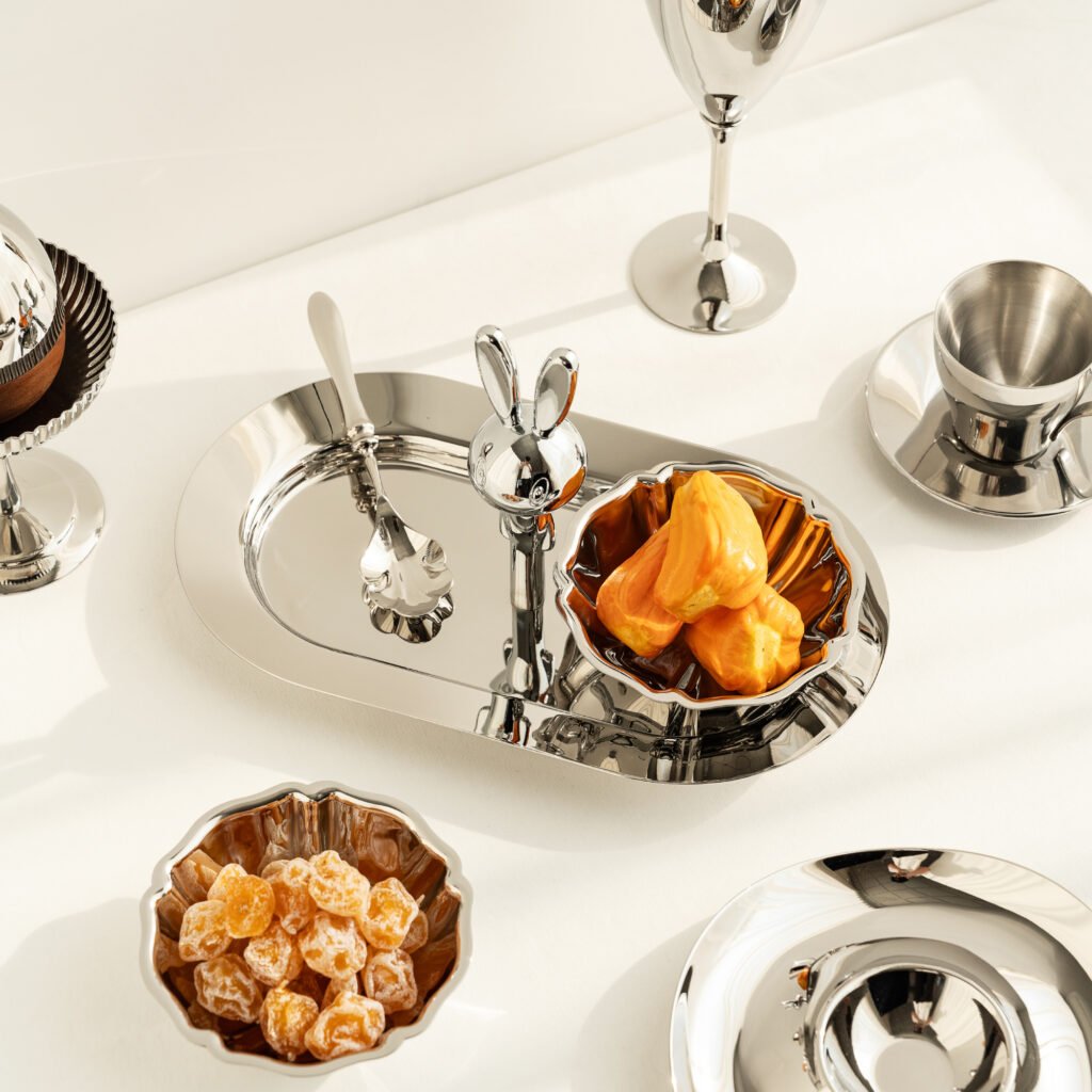 Steel Rabbit Bowl placed on a minimalist white side table, representing Reflective Whimsical Tableware for high-end gifting.