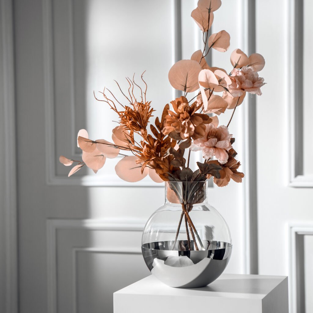 Steel Sphere Vase showcased as a Luxury Mirror Polished Floral Vessel, reflecting a contemporary living room environment on its curved surface.