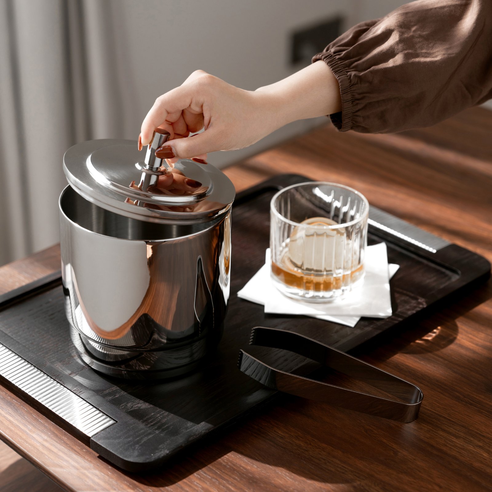 Steel Ice Bucket placed on a luxury marble bar counter, representing Reflective Modernist Tableware for high-end hospitality.