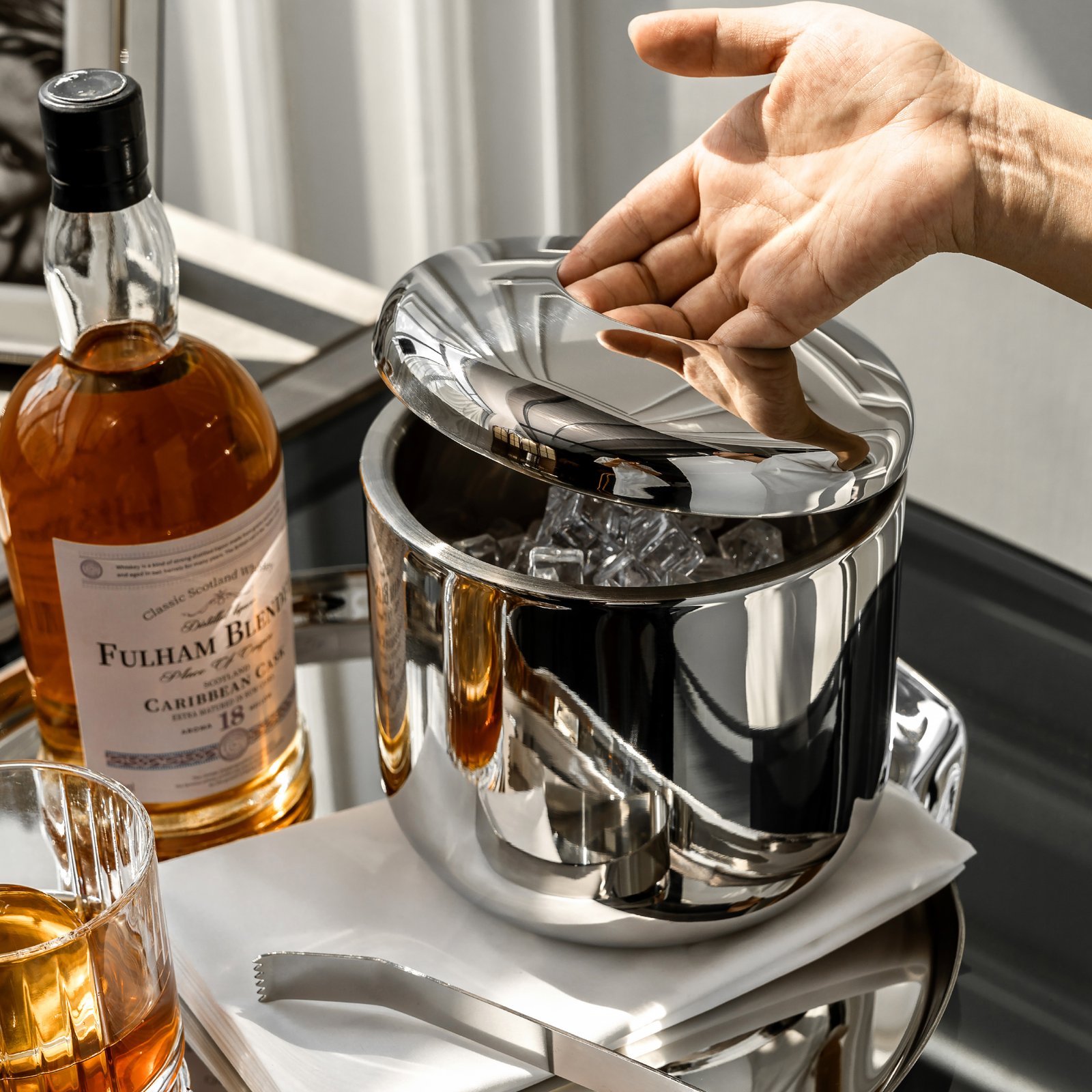 Steel Ice Bucket displayed on a modern granite bar top, representing Reflective Modernist Tableware for high-end hospitality.