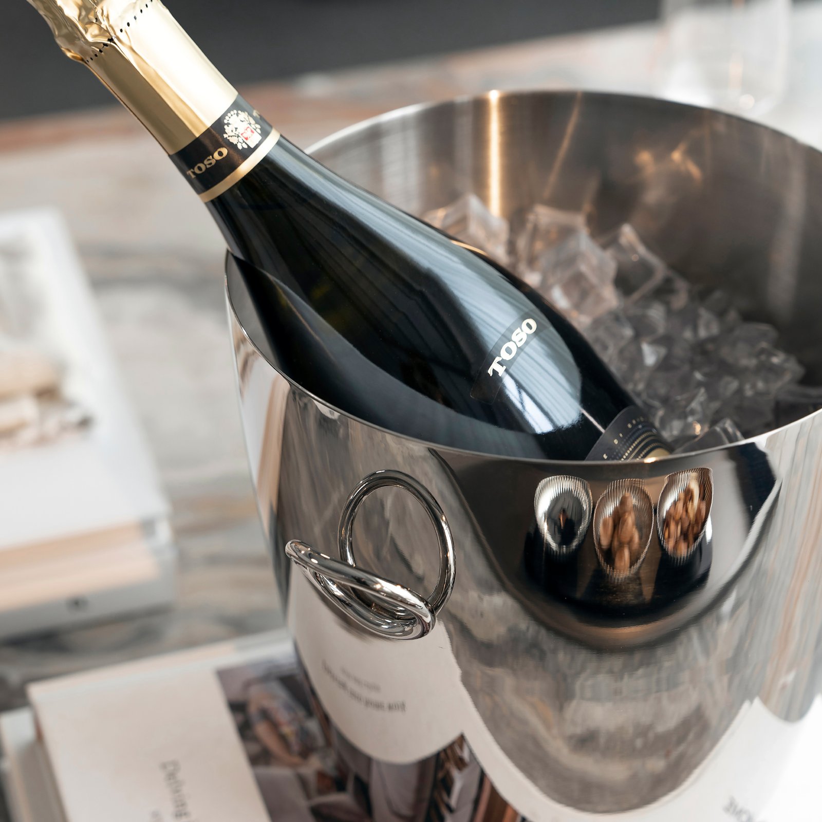 Steel Ice Bucket placed on a modern outdoor lounge table, representing Reflective Modernist Tableware for high-end events.