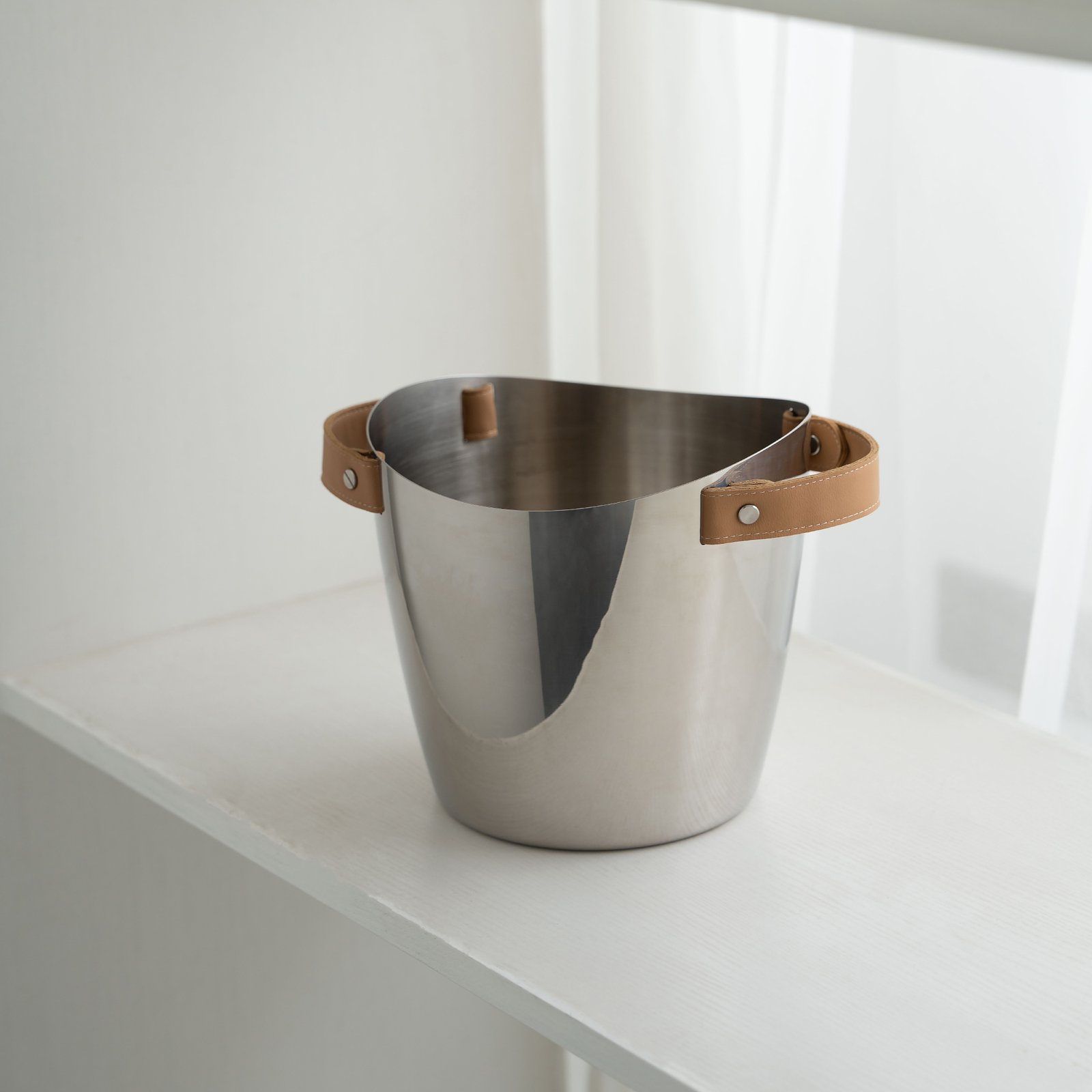 Leather Ice Bucket featuring a dark stitched leather wrap and stainless steel tongs, showcased as an Artisan Hand-Stitched Barware piece.