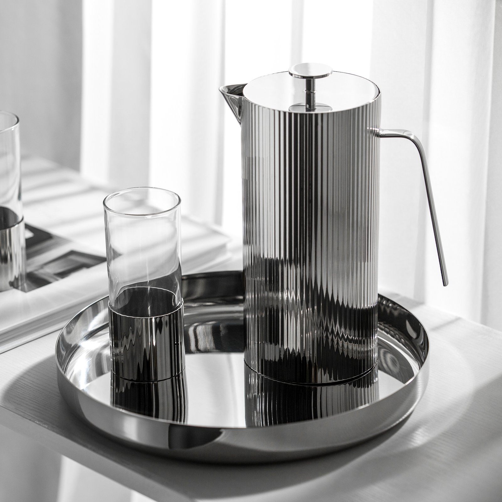 Steel Water Set including a tall pitcher and matching tumblers, showcased as a Premium Metallic Hydration Suite on a marble countertop.