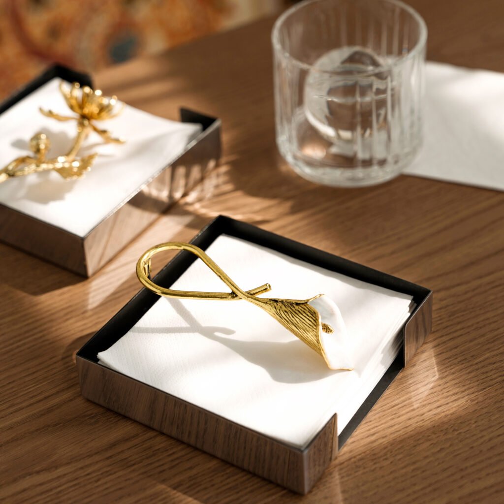 Steel Lily Napkin holder standing on a white linen banquet table, representing Reflective Botanical Dining Art in a luxury setting.