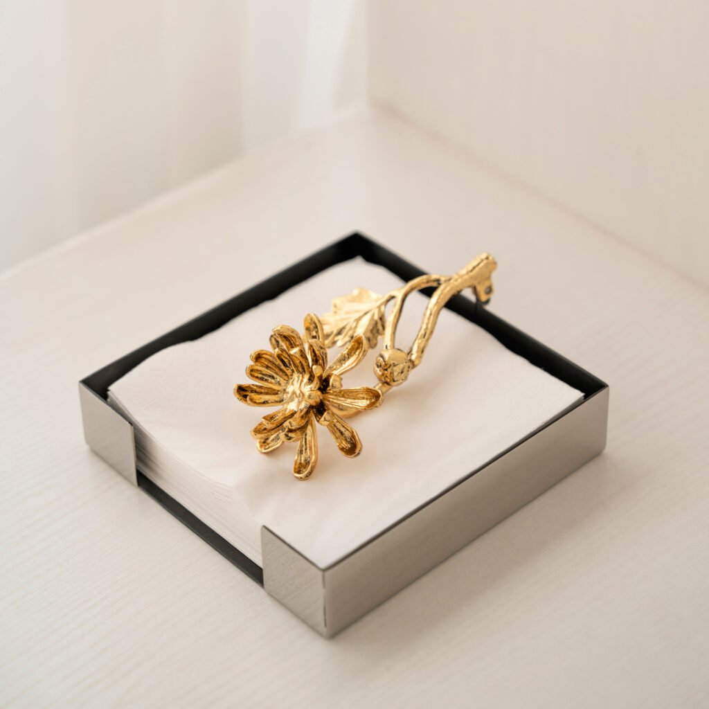 Steel Dahlia Napkin holder standing on a dark velvet tablecloth, representing Reflective Botanical Dining Art in a luxury setting.