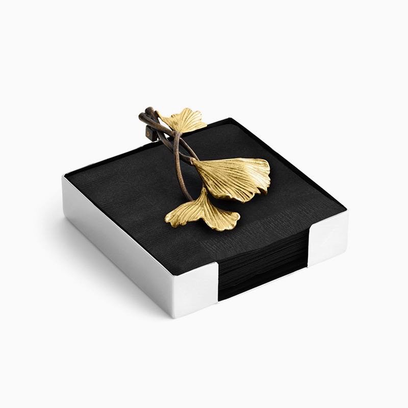 Steel Ginkgo Napkin holder standing on a minimalist wooden dining surface, representing Reflective Botanical Dining Art in a luxury setting.