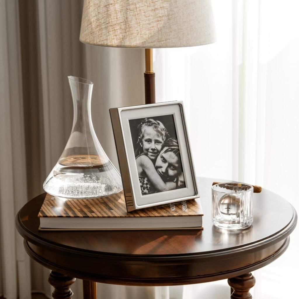 Steel Picture Frame (SS-18) featuring mirror-polished cylindrical steel supports and a crystal-clear frameless glass interface, showcased as a Luxury Mirror Polished Photo Display.