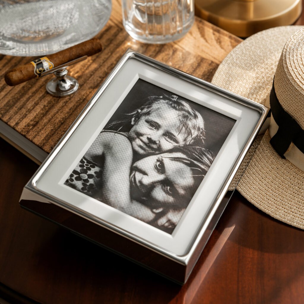 Close-up of the Modernist Frameless Metalware, highlighting the ultra-smooth reflective surface of the steel pillars and the seamless glass integration.