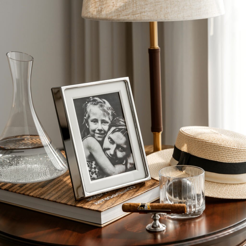 Steel Picture Frame placed on a minimalist black desk beside a designer timepiece, representing Reflective High-End Minimalist Art elegance.