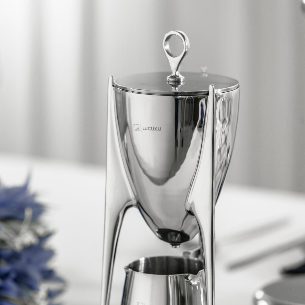 Steel Ding Pitcher (SS-21) featuring a mirror-polished body with ancient tripod-inspired proportions and a dramatic arcing handle, showcased as a Luxury Mirror Polished Cultural Server.