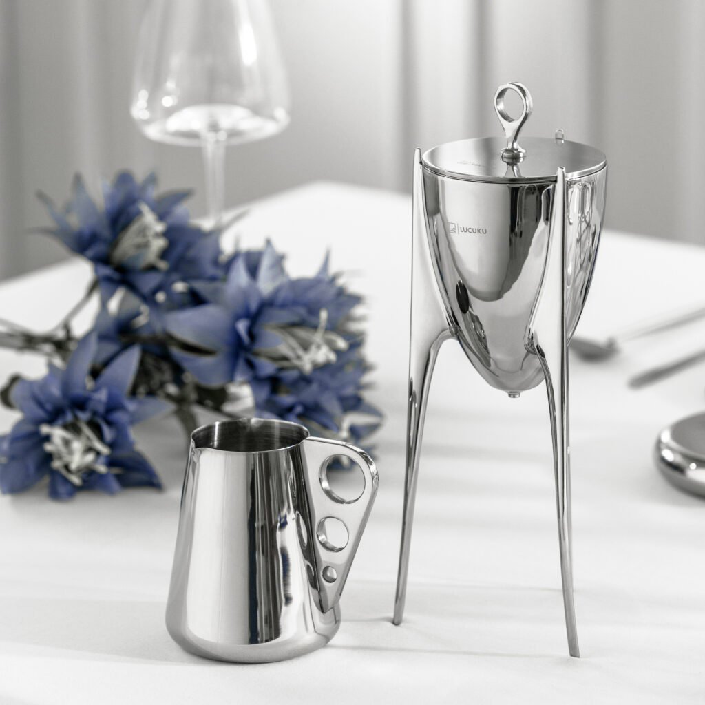 Close-up of the Modernist Tripod Metalware, highlighting the precision-curved pouring lip and the flawless, panoramic reflection across the steel shoulders.