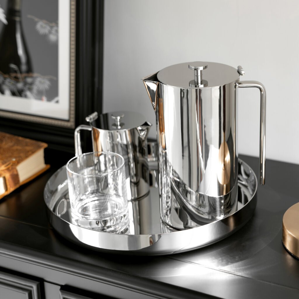 Close-up of the Modernist Geometric Metalware, highlighting the precision-engineered narrow spout and the flawless, panoramic reflection across the steel surface.