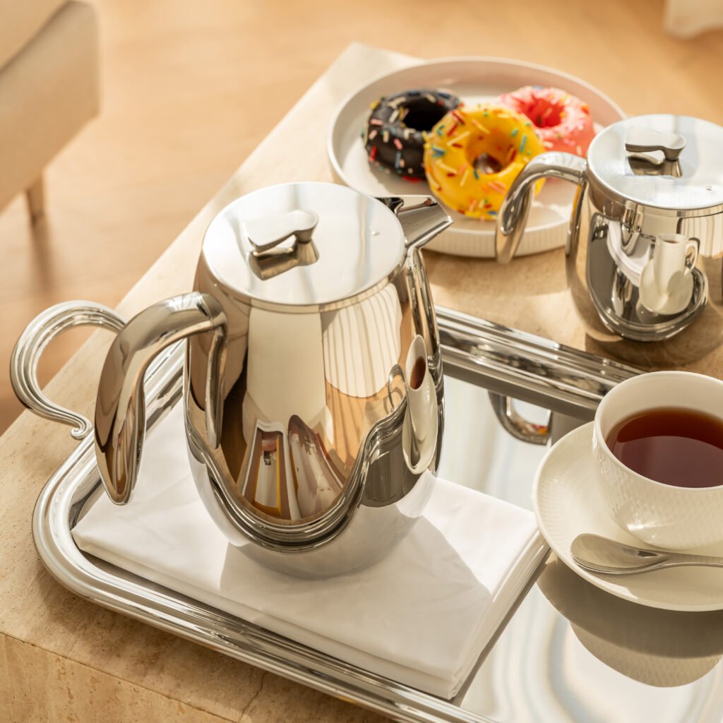 Steel Falla Pitcher (SS-30) featuring a mirror-polished tilted body and a sweeping ergonomic handle, showcased as a Luxury Mirror Polished Fluid Server.