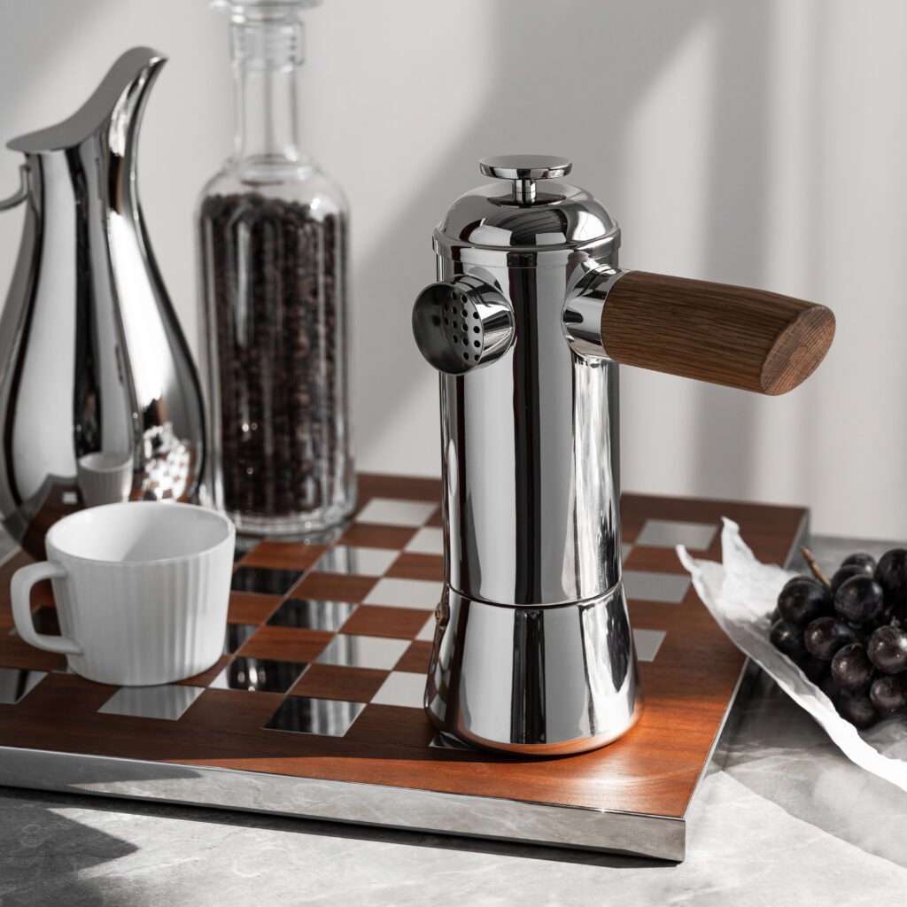 Close-up of the Modernist Slender Metalware, highlighting the precision-engineered pouring spout and the flawless, vertical reflection across the elongated steel surface.