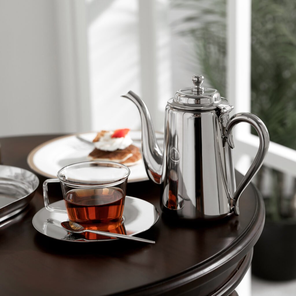 Close-up of the Modernist Japanese Metalware, highlighting the thick-gauge handle joint and the flawless, jewel-grade panoramic reflection of the circular kettle body.
