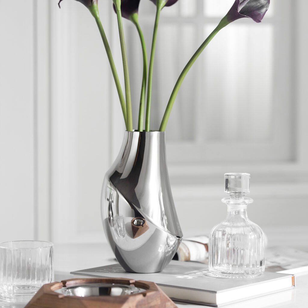 Steel Minimalist Vase (SS-38) featuring a mirror-polished cylindrical body holding a single calla lily, showcased as a Luxury Mirror Polished Flower Vessel.