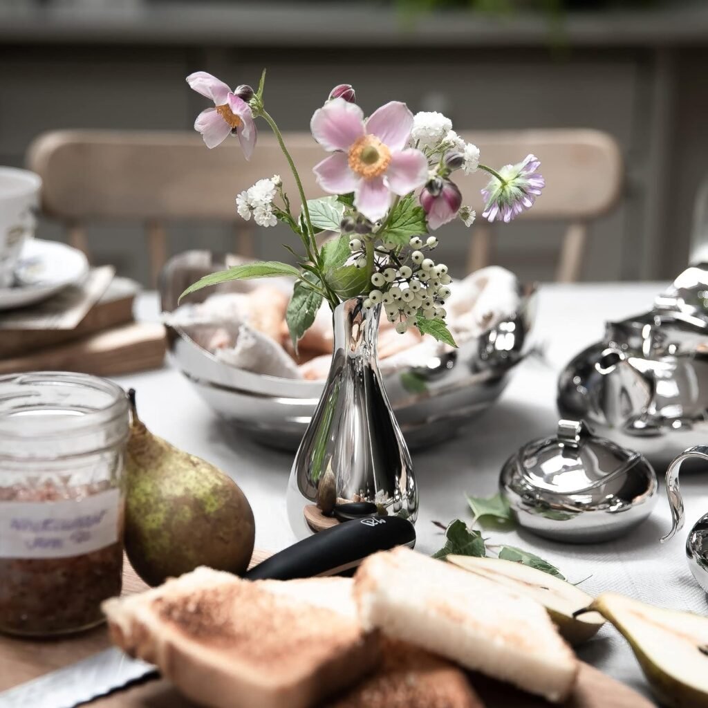 Steel Petit Vase (SS-39) featuring a miniature mirror-polished cylindrical body holding a delicate single stem, showcased as a Luxury Mirror Polished Desktop Vessel.