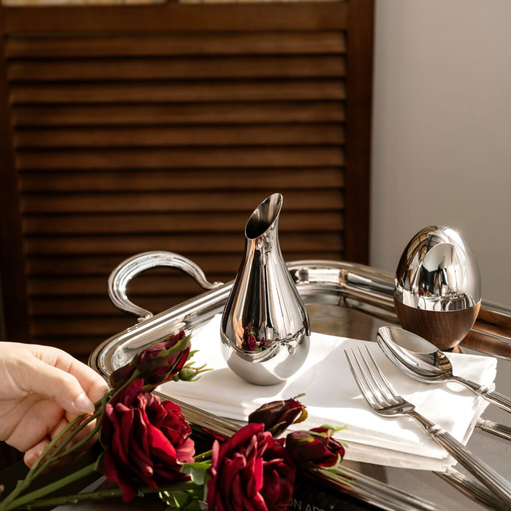 Steel Petit Vase placed on a dark walnut executive desk beside a premium fountain pen, representing Reflective High-End Tabletop Art elegance.