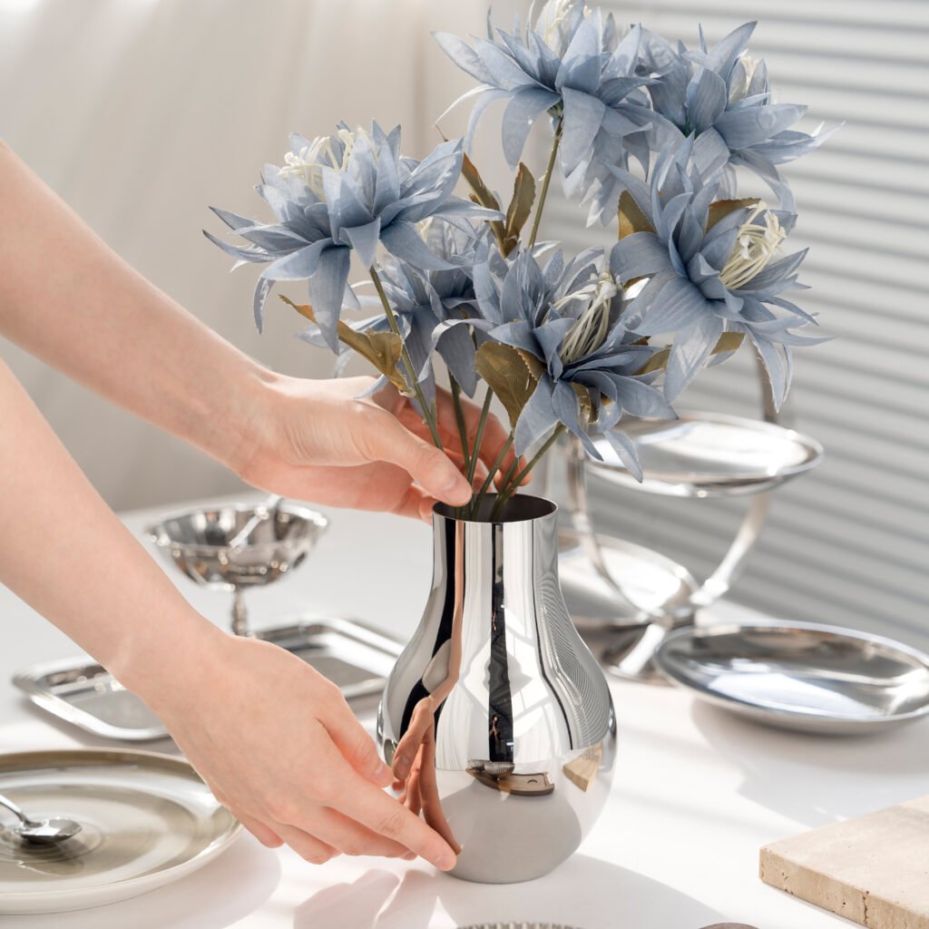 Steel Bulb Vase (SS-40) featuring a mirror-polished bulb-shaped body holding a minimalist floral branch, showcased as a Luxury Mirror Polished Artistic Vessel.