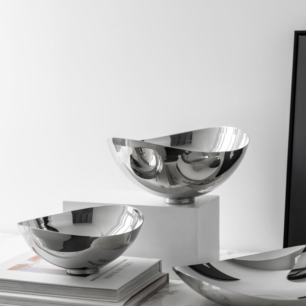 Close-up of the Modernist Modular Metalware, highlighting the precision-engineered nesting fit and the complex light reflections between the bowls.
