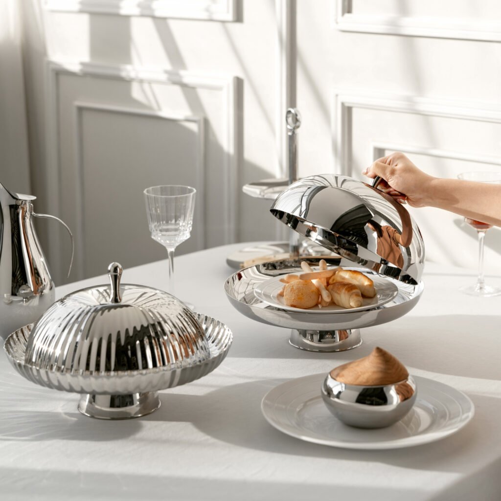 Close-up of the Modernist Tactile Dinnerware, highlighting the precision-engineered linear ribs and the flawless reflection on the stainless steel dome.