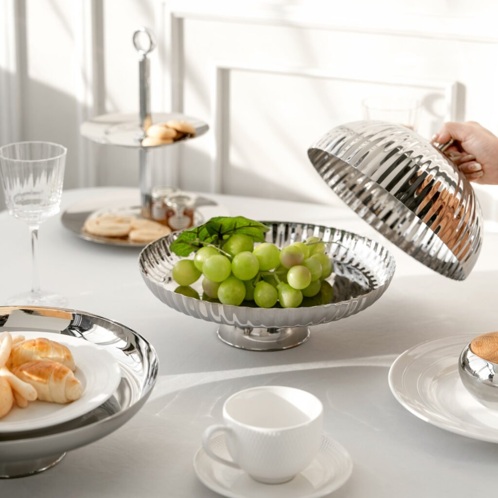 Steel Ribbed Platter set placed on a dark linen tablecloth, slightly revealing a gourmet entree, representing Reflective Architectural Table Art elegance.