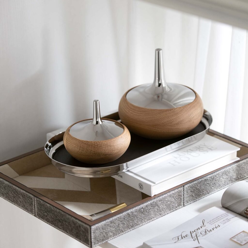 Close-up of the Modernist Botanical Metalware, highlighting the flawless, liquid-like reflection across the organic steel curves and precision lid fit.