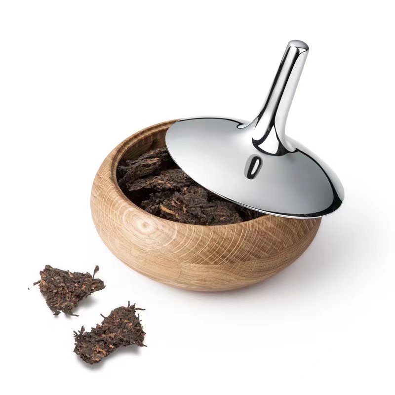 Steel Onion Jar placed on a dark basalt countertop beside fresh organic herbs, representing Reflective High-End Culinary Art elegance.