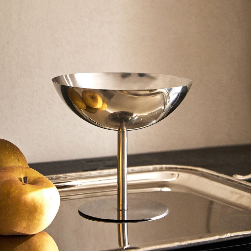 Steel Ice Cream Bowl placed on a dark slate surface with a scoop of artisanal vanilla bean ice cream, representing Reflective Minimalist Serving Art.