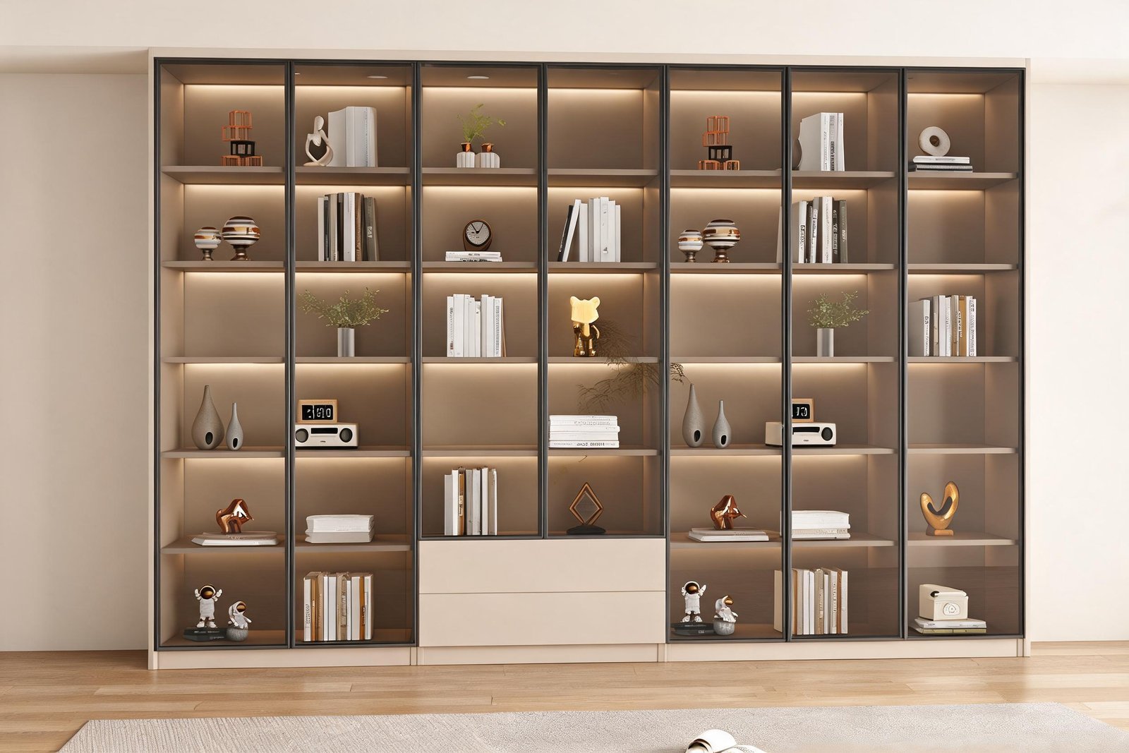 Home 31 Bookcase with glass doors, a full height cream wall unit with thin black framed clear glass doors and warm LED shelf lighting in a modern living room