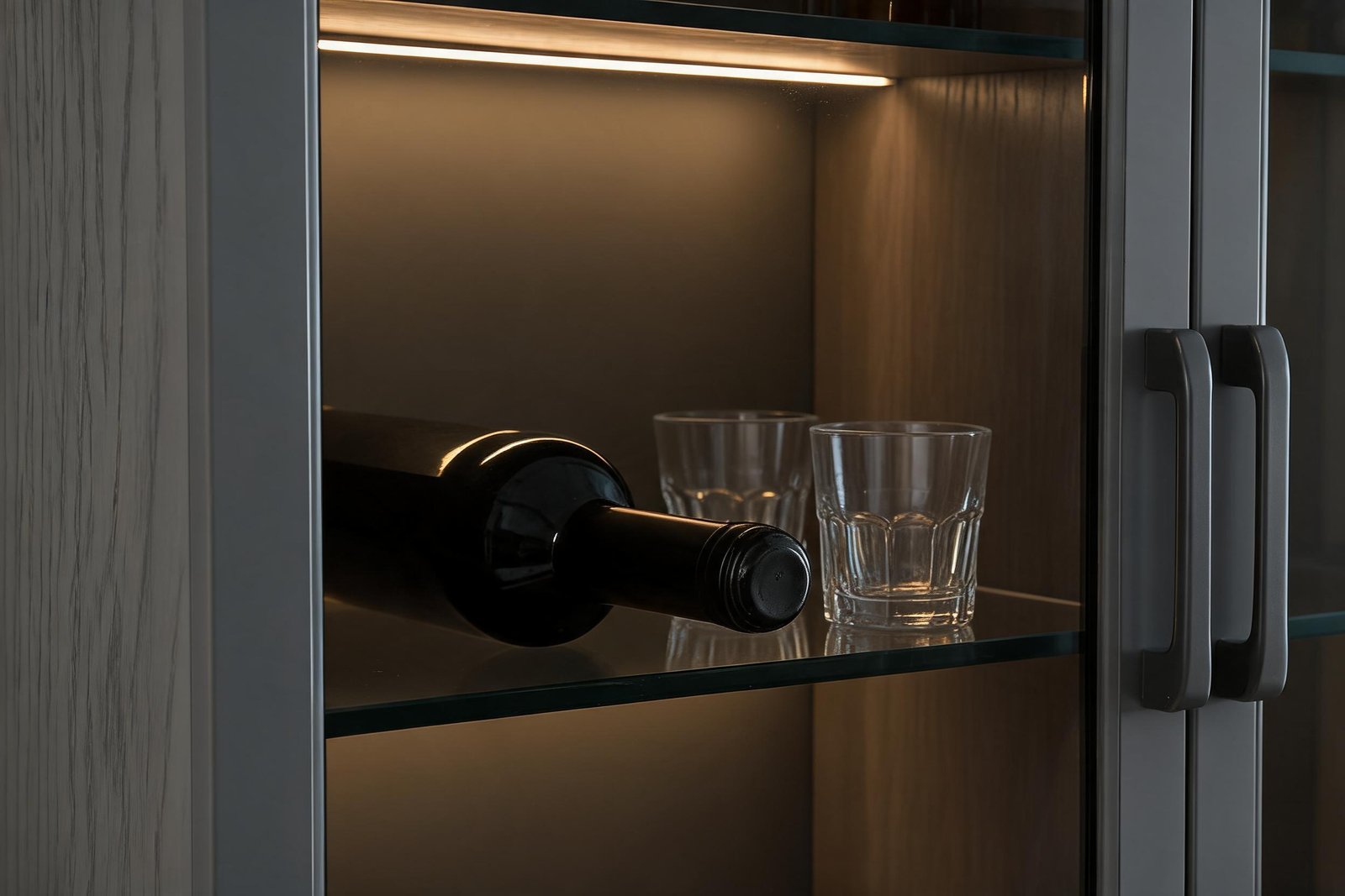Display cabinet depth detail: a 750 ml bottle lying neck out on a glass shelf with the LED strip above lighting the label